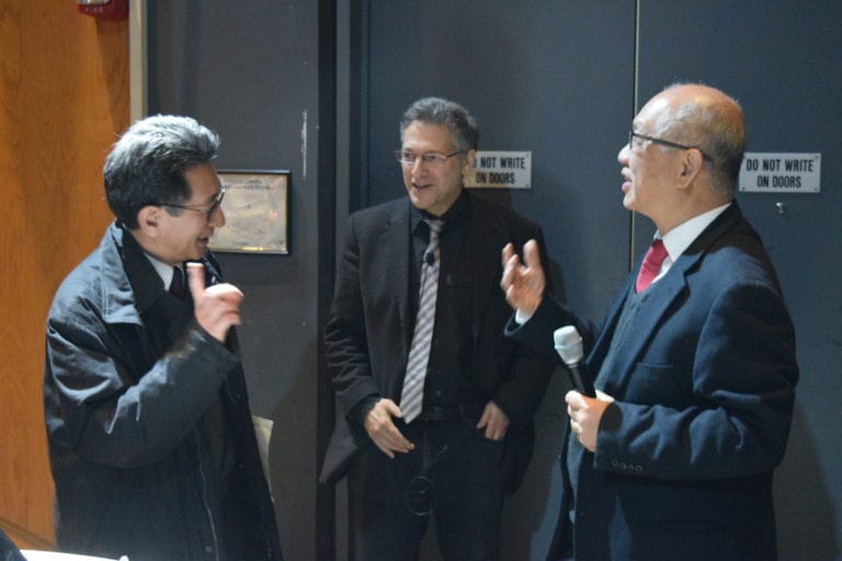 Three People Talking In Front of door in the First Annual Yip Lecture