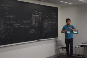 A Man, Wearing Blue Half Shirt, Presenting in Workshop on Topology and Dynamics in Quantum Matter