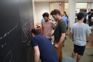 Three Men, Wearing T-Shirt, Drawing Something in BlackBoard in Beginning of the Year Party!